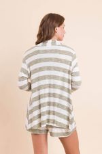 na foto, a modelo está vestindo o casaqueto listrado verde com off white, a regata decotão verde militar e short listras verde com off de costas