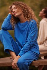 foto-da-modelo-sentada-usando-o-conjunto-de-moletom-azul-com-friso